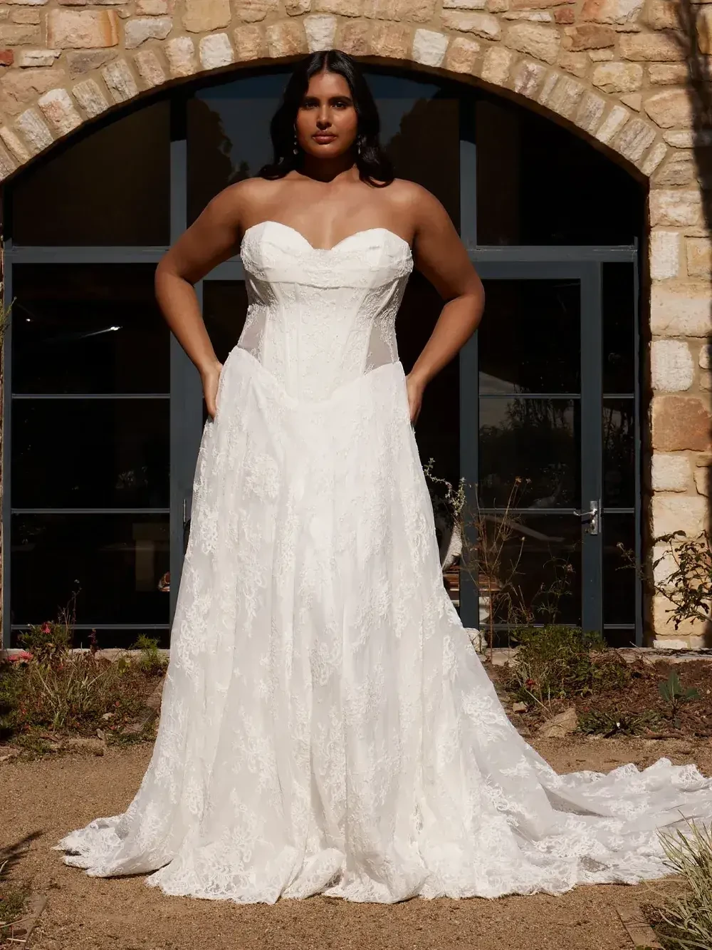 model is wearing a strapless lace bridal gown