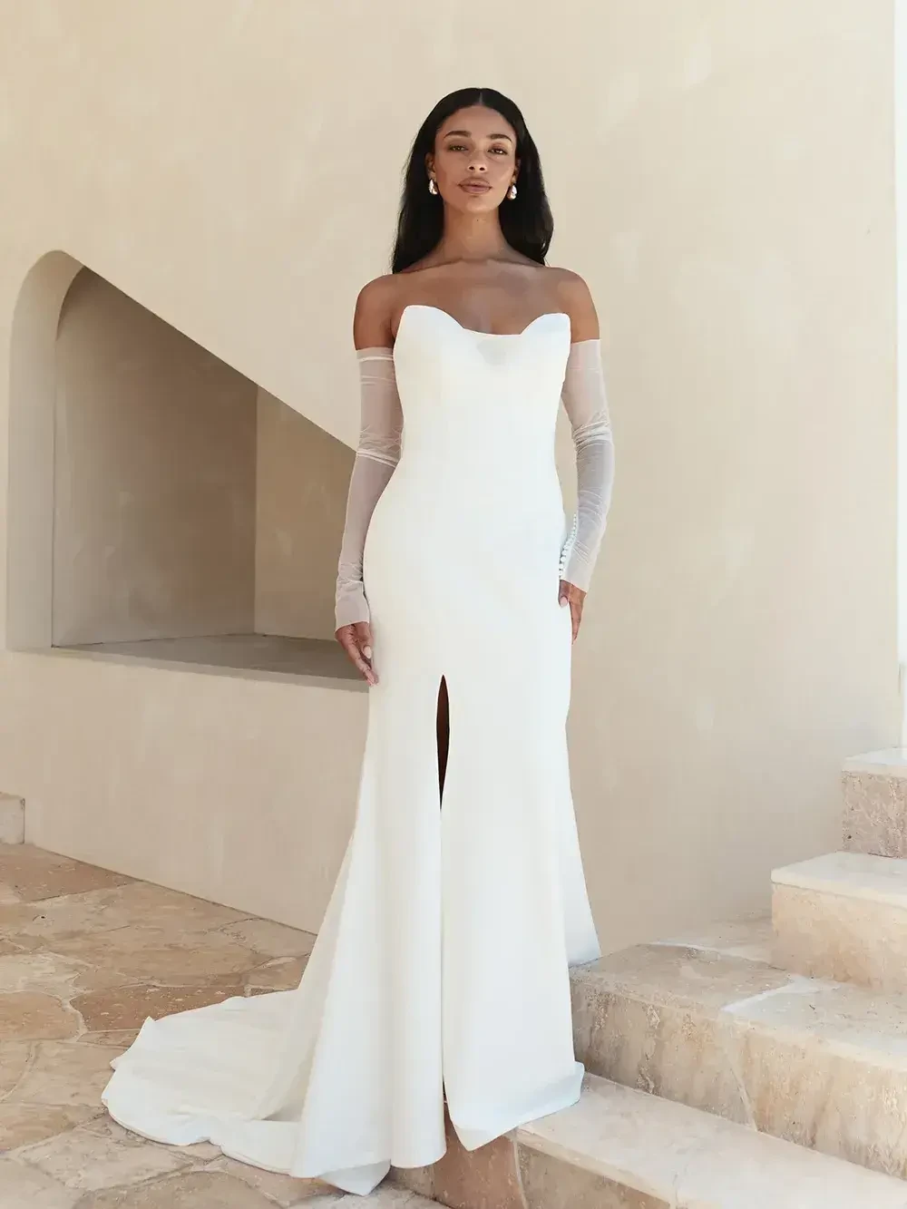 model is wearing a strapless sheath bridal gown