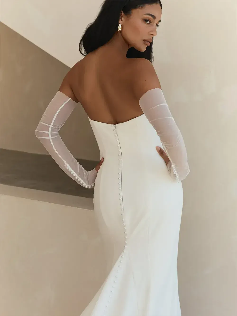 model is wearing a strapless sheath bridal gown