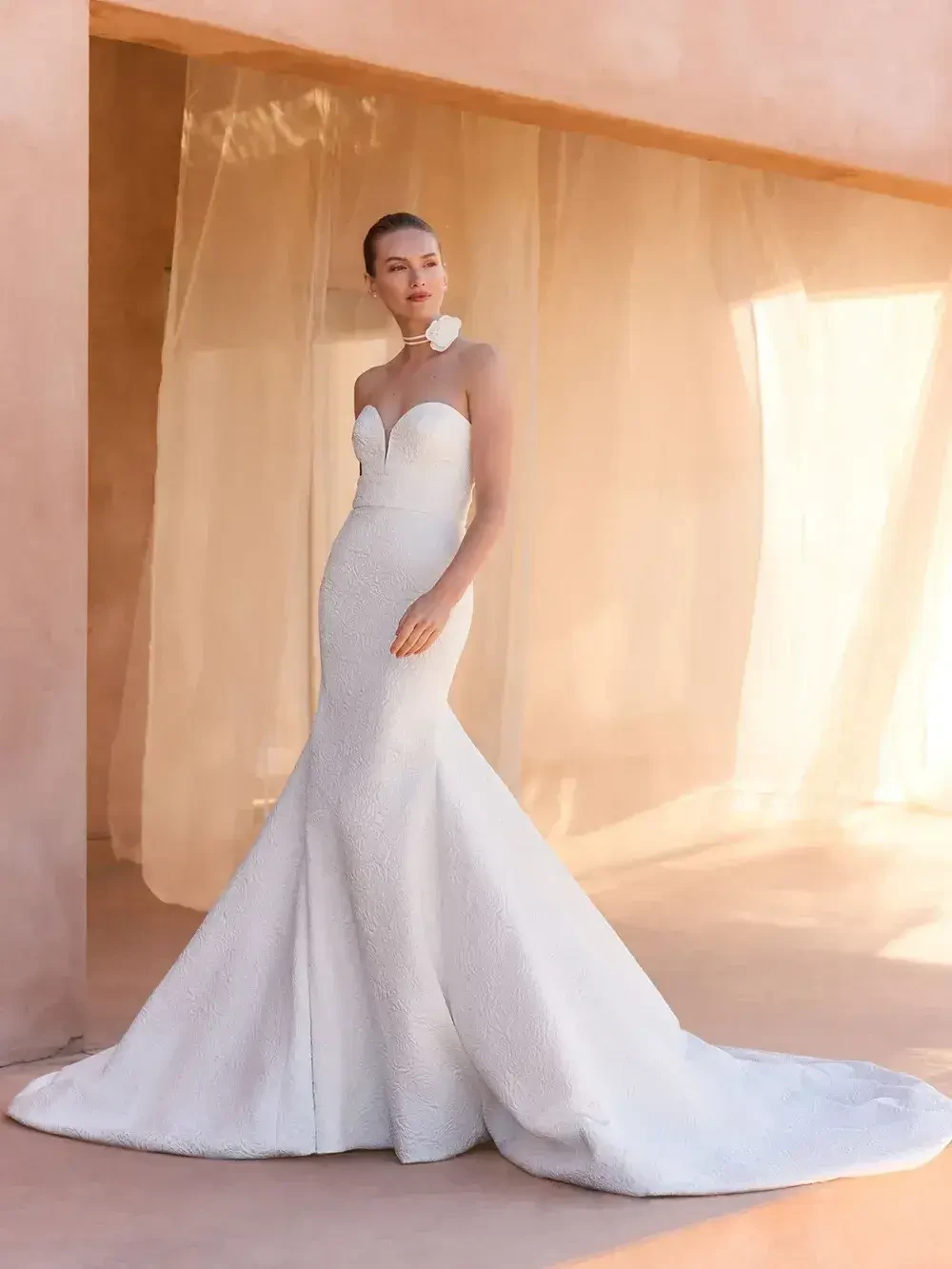 model is wearing a sleek strapless bridal gown