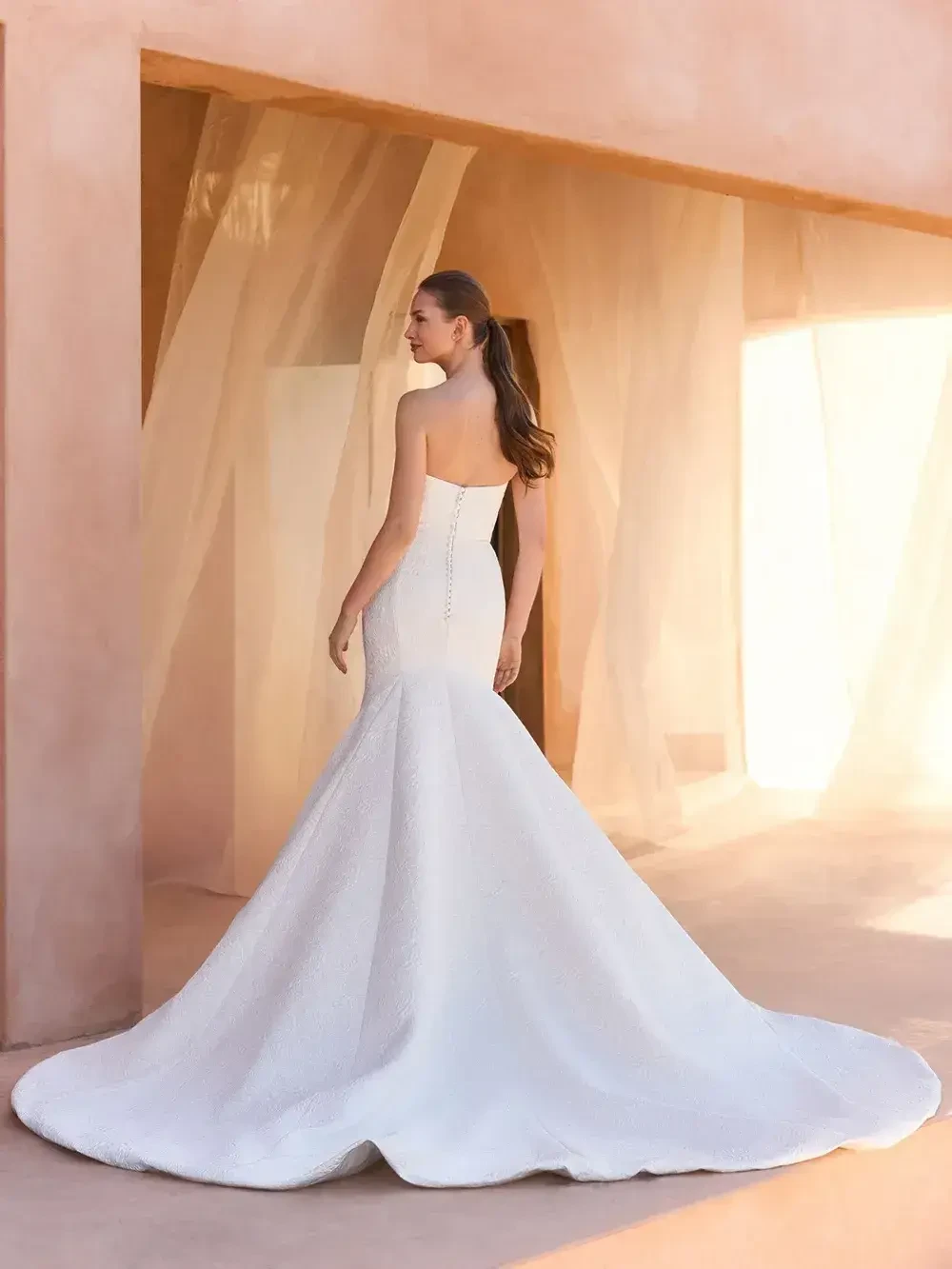 model is wearing a sleek strapless bridal gown