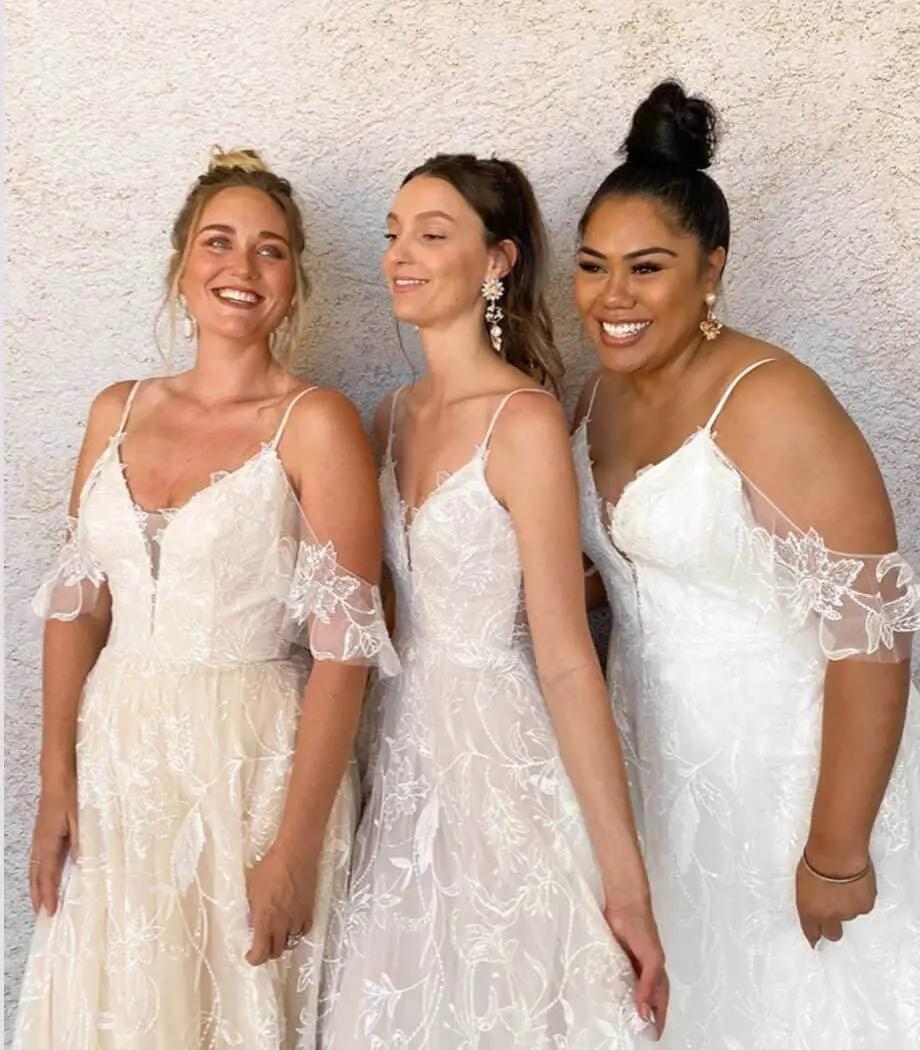 Smiling models wearing a white dresses. Mobile image